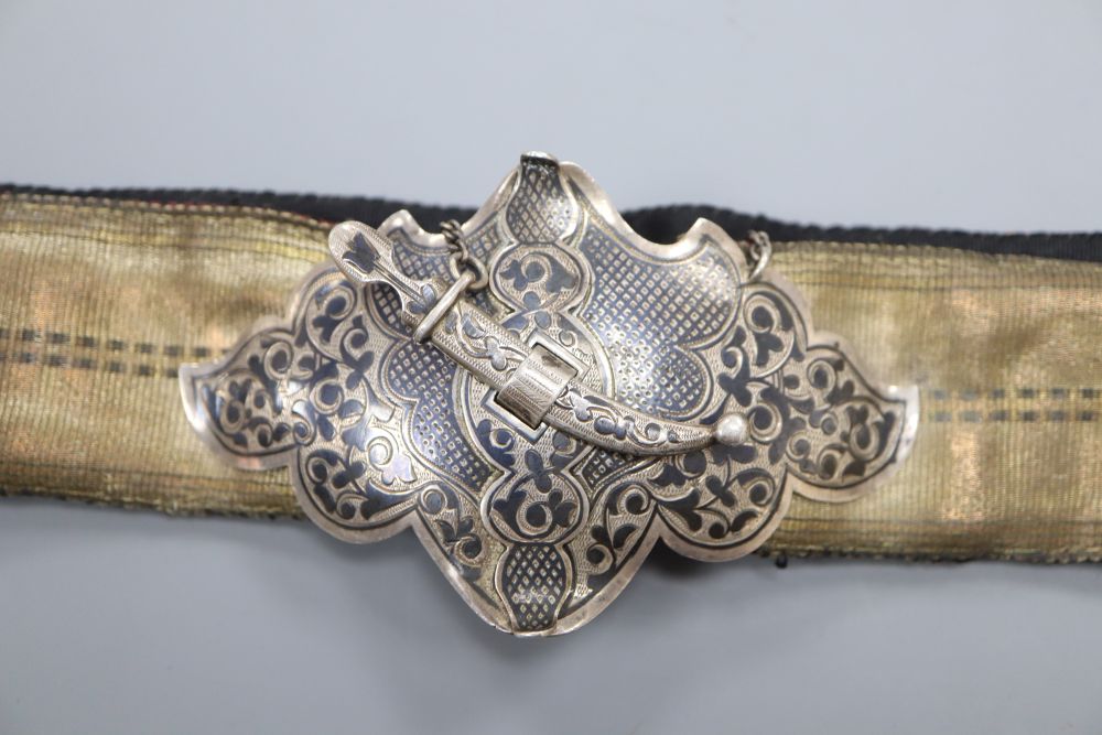 An Islamic silver and niello mounted brocade belt